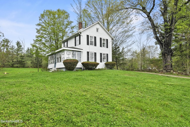 view of front facade featuring a chimney and a front yard