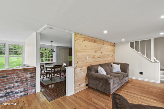 living room with stairs, wood finished floors, recessed lighting, and a decorative wall