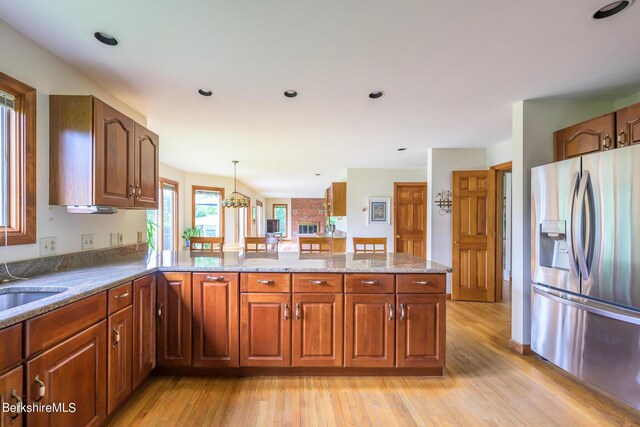 26 Filomena Dr, Pittsfield, MA 01201 - kitchen featuring stainless steel fridge with ice dispenser, light wood-type flooring, a peninsula, and brown cabinets