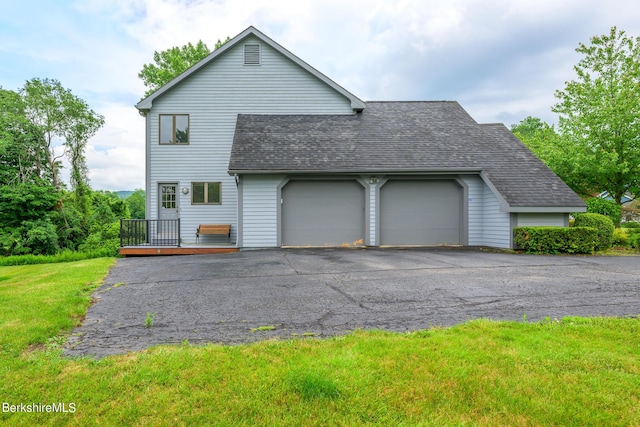 26 Filomena Dr, Pittsfield, MA 01201 - view of side of property featuring roof with shingles, a deck, an attached garage, driveway, and a lawn