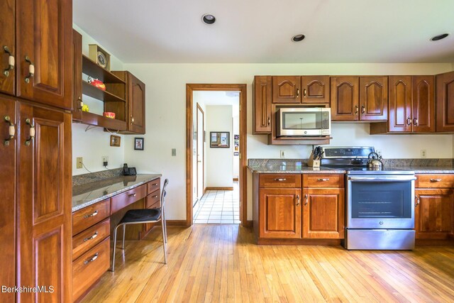 26 Filomena Dr, Pittsfield, MA 01201 - kitchen featuring appliances with stainless steel finishes, open shelves, light wood-type flooring, and dark stone countertops