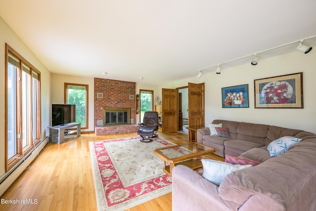 26 Filomena Dr, Pittsfield, MA 01201 - living area with a baseboard radiator, light wood-type flooring, track lighting, and a brick fireplace