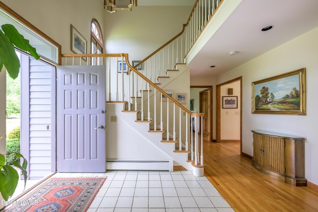 26 Filomena Dr, Pittsfield, MA 01201 - entryway with a baseboard radiator, stairs, light tile patterned flooring, a chandelier, and a high ceiling
