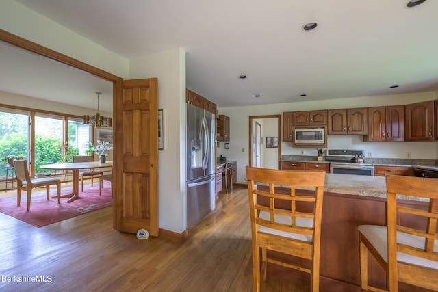 26 Filomena Dr, Pittsfield, MA 01201 - kitchen with stainless steel appliances, dark wood-type flooring, a kitchen breakfast bar, light countertops, and a chandelier