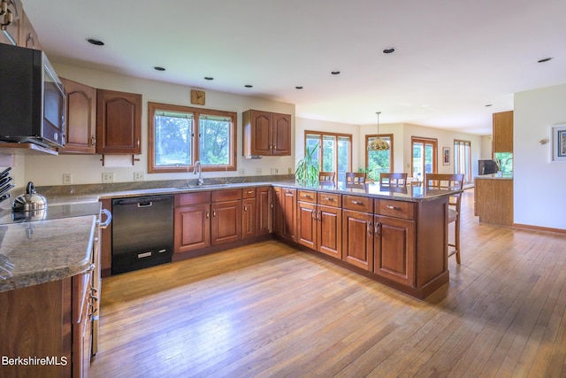 26 Filomena Dr, Pittsfield, MA 01201 - kitchen with dishwasher, a peninsula, a breakfast bar, light wood finished floors, and brown cabinets