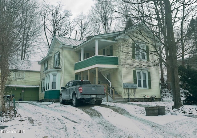 view of snow covered exterior featuring a garage and a balcony