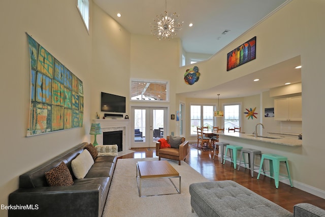 living room featuring a chandelier, a fireplace with flush hearth, baseboards, dark wood-style flooring, and recessed lighting