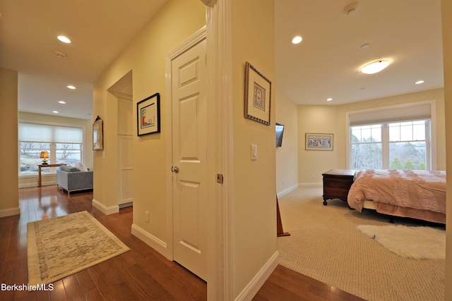 hallway with baseboards, dark wood-type flooring, and recessed lighting