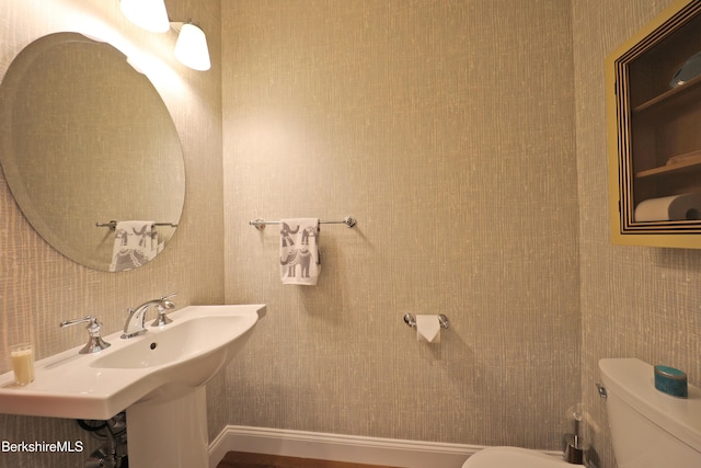 half bathroom featuring toilet and a sink