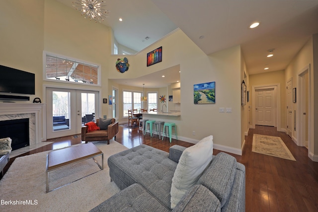 living room with recessed lighting, baseboards, dark wood-style floors, and an inviting chandelier
