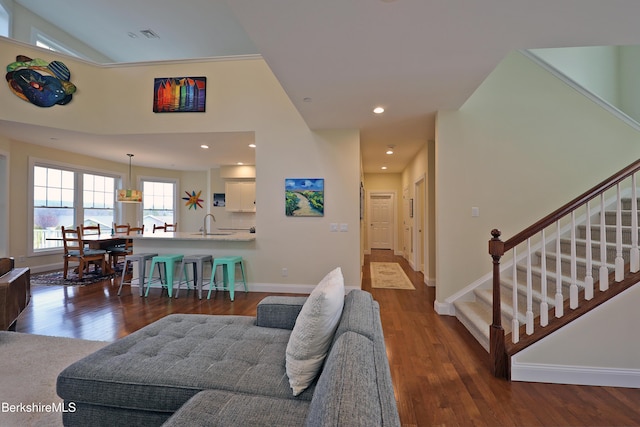 living area featuring stairs, dark wood finished floors, baseboards, visible vents, and recessed lighting