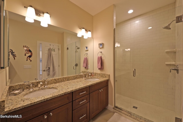 bathroom featuring recessed lighting, a sink, double vanity, and a stall shower