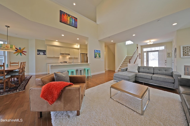 living area featuring recessed lighting, stairs, wood finished floors, and baseboards