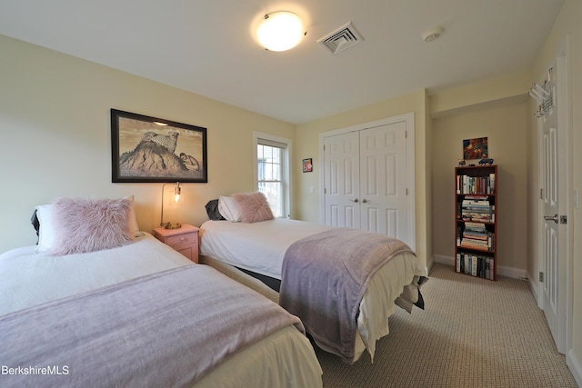 bedroom with a closet, visible vents, baseboards, and light carpet