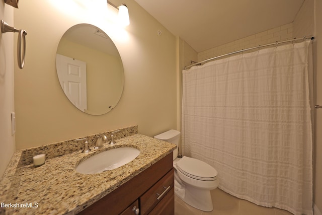 bathroom with toilet, vanity, and tile patterned floors