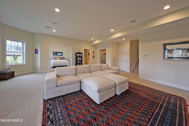 carpeted living area featuring recessed lighting, baseboards, visible vents, and stairs