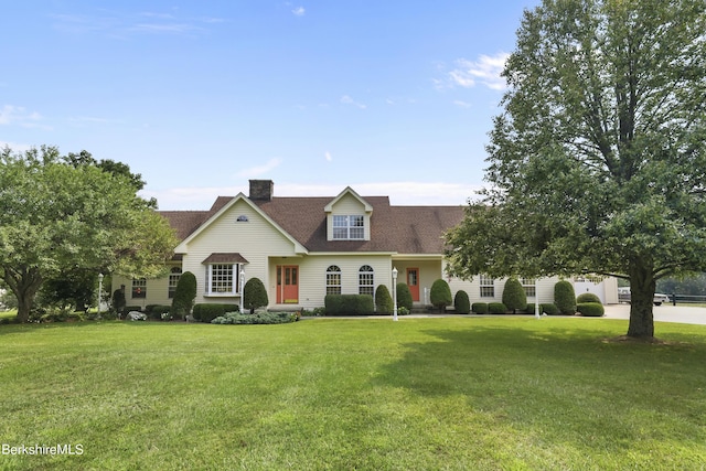 new england style home featuring a front yard