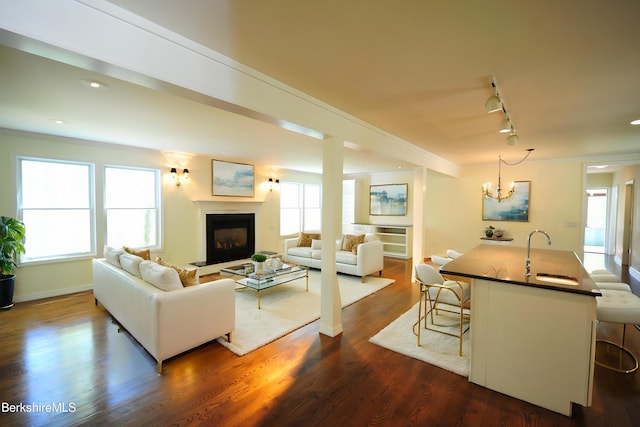 232 Harrington Rd, Otis, MA 01253 - living room with track lighting, a fireplace, dark wood-style flooring, a chandelier, and baseboards