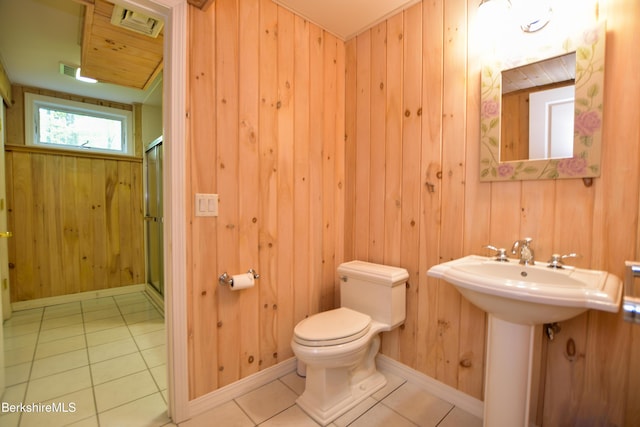 232 Harrington Rd, Otis, MA 01253 - bathroom featuring toilet, tile patterned floors, a stall shower, wood walls, and a sink