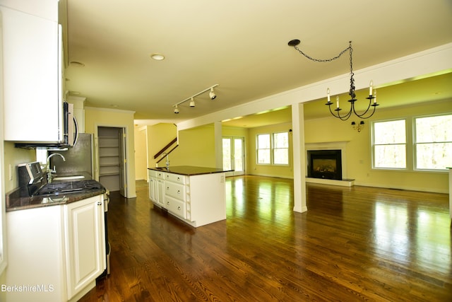 232 Harrington Rd, Otis, MA 01253 - kitchen featuring open floor plan, white cabinets, a fireplace with raised hearth, dark wood-style flooring, and a sink