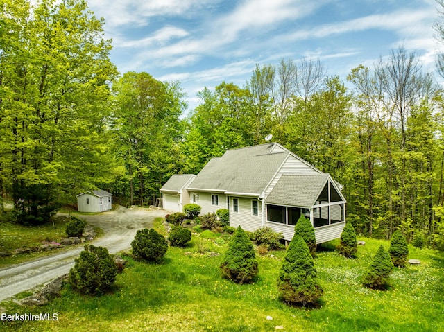 232 Harrington Rd, Otis, MA 01253 - view of front of home with dirt driveway, an attached garage, an outbuilding, a sunroom, and a shingled roof