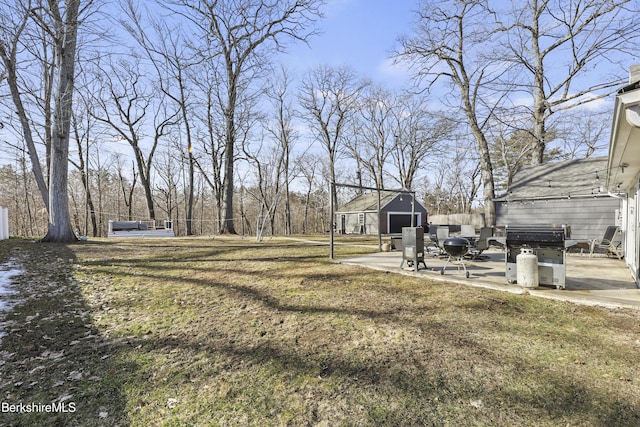 view of yard with an outdoor structure, a patio, and fence