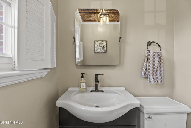 bathroom featuring plenty of natural light, toilet, and vanity