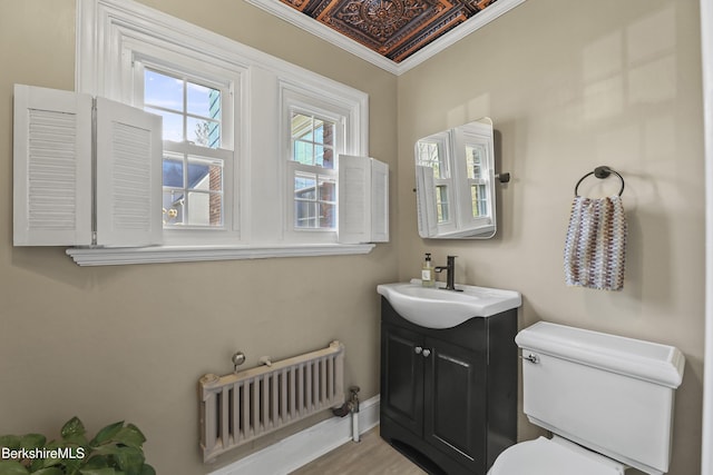 bathroom with toilet, ornamental molding, an ornate ceiling, radiator, and vanity