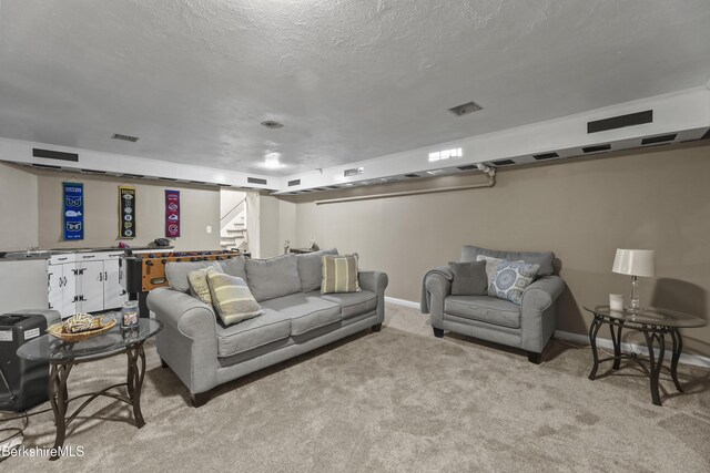 living area featuring a textured ceiling, stairway, baseboards, and light carpet