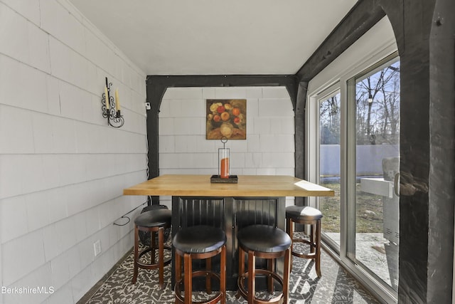 dining room with concrete block wall