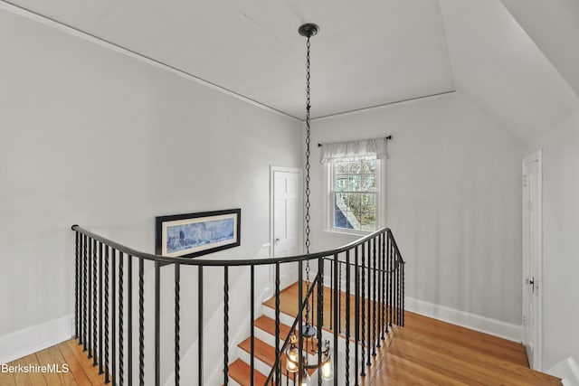 staircase with baseboards, lofted ceiling, and wood finished floors