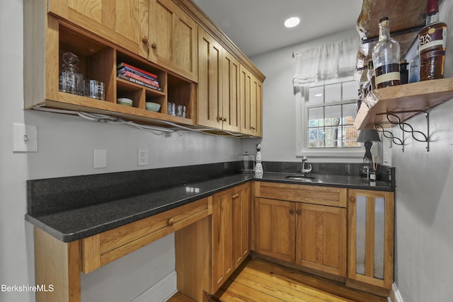 kitchen featuring open shelves, light wood-style flooring, recessed lighting, brown cabinetry, and a sink