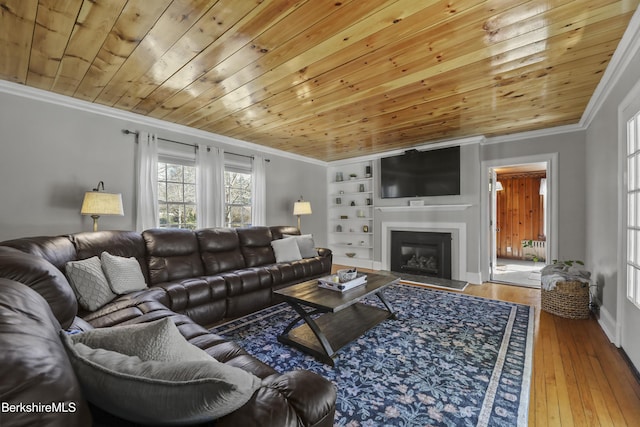 living room featuring crown molding, built in features, and wood ceiling