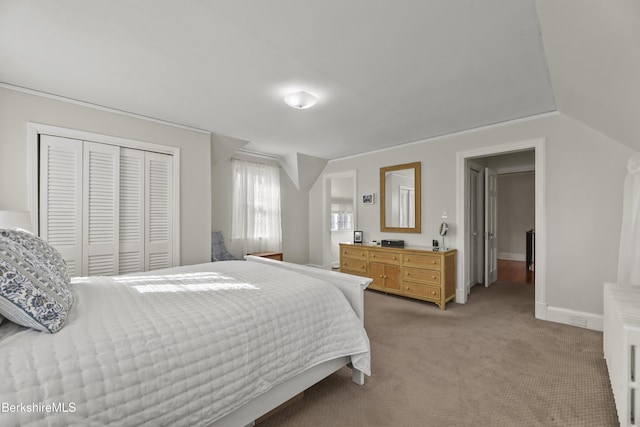 bedroom featuring a closet, light carpet, and baseboards