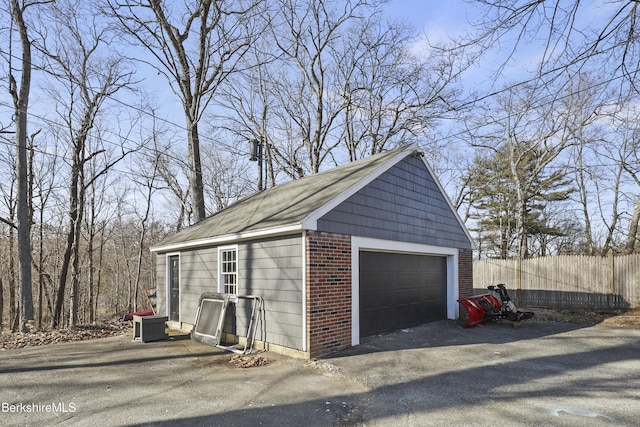 detached garage featuring fence