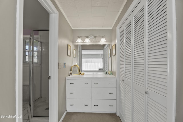 bathroom with vanity, a shower stall, a closet, and ornamental molding