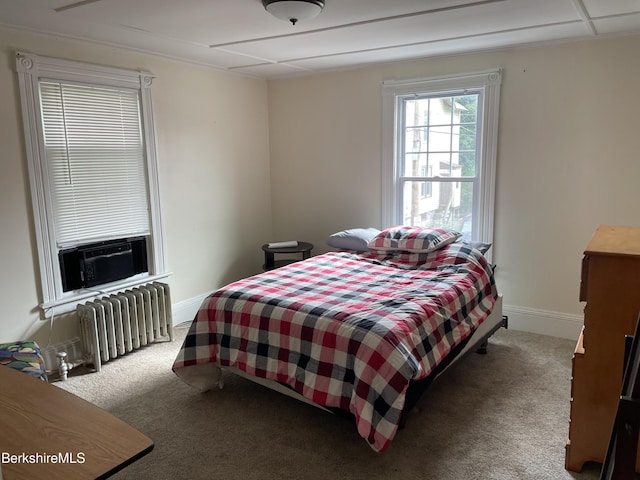 carpeted bedroom with cooling unit and radiator heating unit