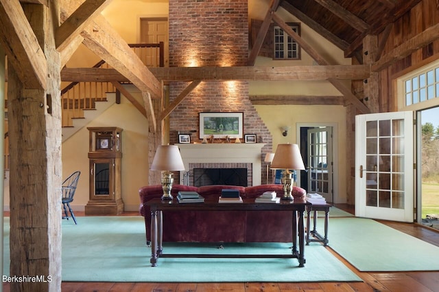 living room with wooden ceiling, beamed ceiling, high vaulted ceiling, hardwood / wood-style floors, and a fireplace