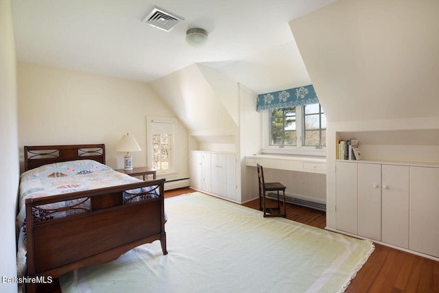 bedroom with vaulted ceiling, a baseboard radiator, and light hardwood / wood-style flooring