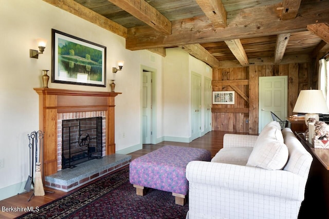 living room featuring beam ceiling, wood ceiling, wooden walls, and a brick fireplace