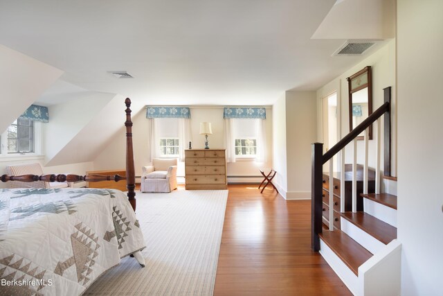 bedroom featuring wood-type flooring and a baseboard heating unit