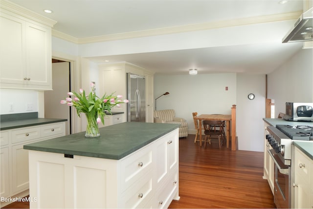 kitchen with white cabinetry, crown molding, appliances with stainless steel finishes, and dark wood-type flooring