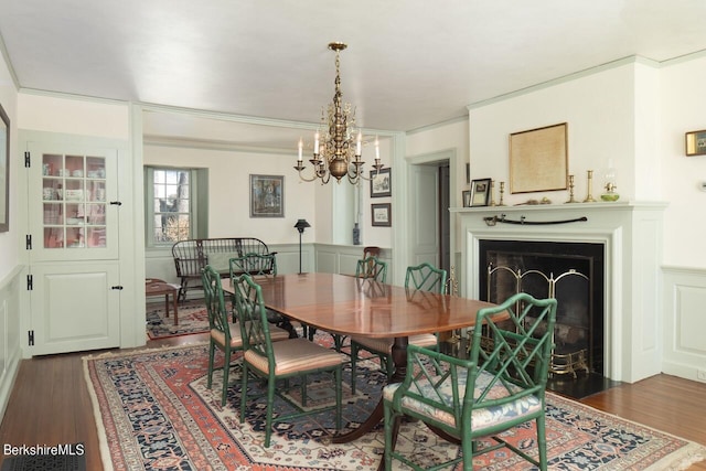 25 Sheffield Rd, Egremont, MA 01230 - dining space with a chandelier, wood finished floors, a fireplace with flush hearth, and ornamental molding