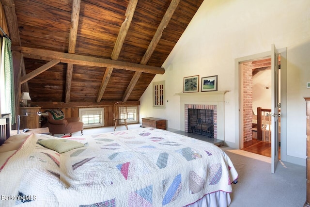 carpeted bedroom featuring high vaulted ceiling, beamed ceiling, wood ceiling, and a brick fireplace