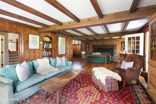 living room with wood walls, beamed ceiling, and dark hardwood / wood-style floors