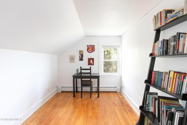 office space featuring baseboards, baseboard heating, vaulted ceiling, and light wood-type flooring