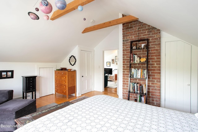 bedroom featuring lofted ceiling with beams and wood finished floors
