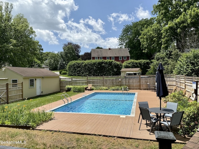 2 Copper Beech Ln, Great Barrington, MA 01230 - view of swimming pool featuring a wooden deck, a fenced backyard, view of scattered trees, an outdoor structure, and outdoor dining area