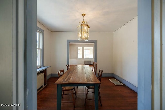 dining room featuring a wealth of natural light, radiator heating unit, and an inviting chandelier