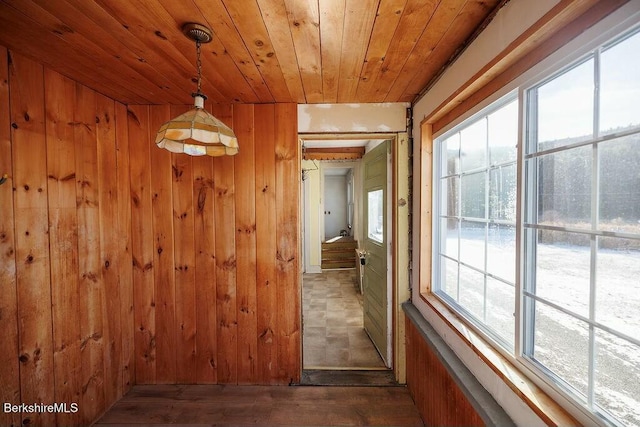 hallway with wooden walls, dark wood-type flooring, and wooden ceiling